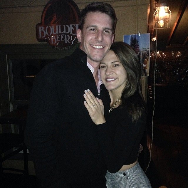 Alex & Breauna Kanzler posing together in a bar with 'Boulder Beer' sign in the background