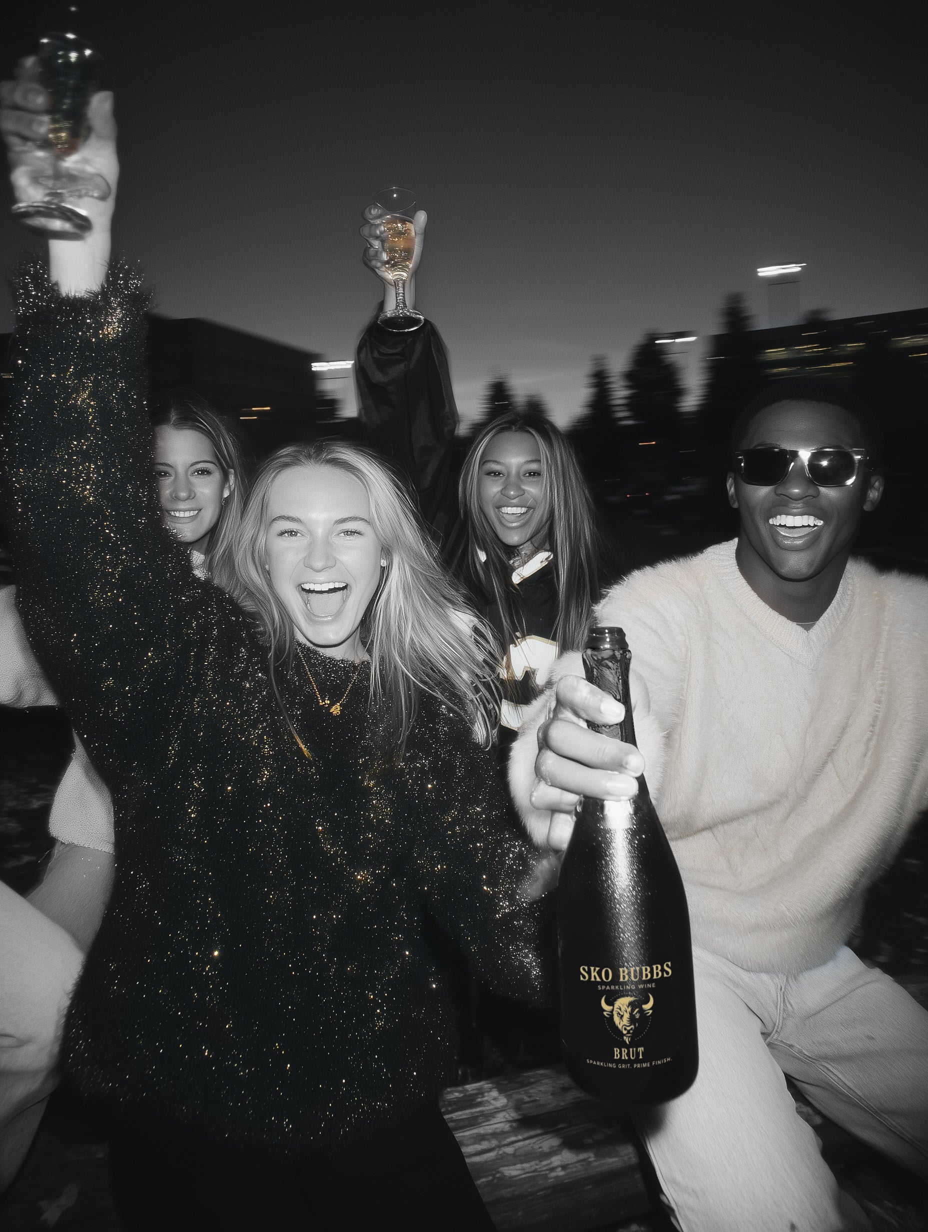 Group of people celebrating with bottles of Sko Bubb's beer at night.